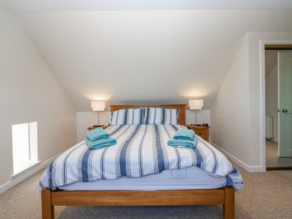 A bedroom with a bed and towels at Meadowgreen Farmhouse in Forfar
