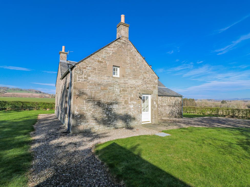 An exterior view of a stone house with a garden at Meadowgreen Farmhouse in Forfar
