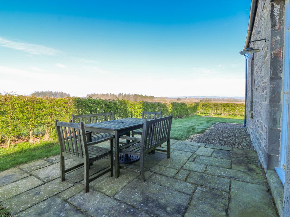 A table and chairs on a patio at Meadowgreen Farmhouse in Forfar