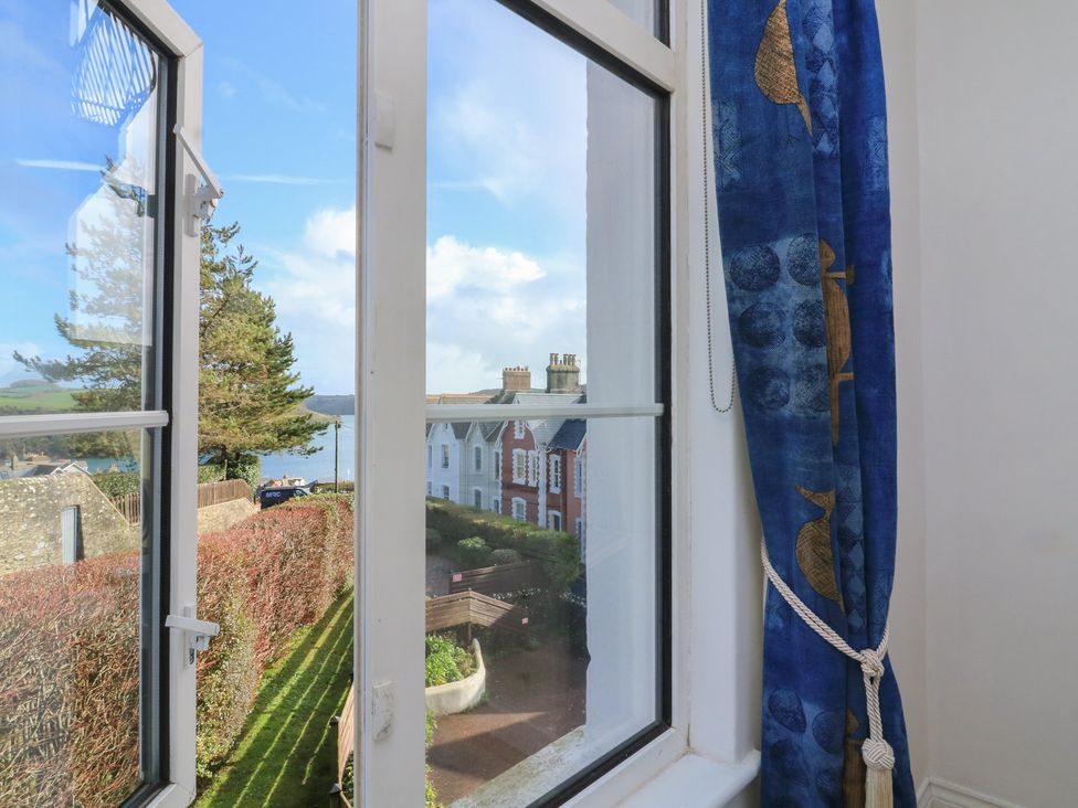 A window with a view of houses and trees at 4 The Elms Salcombe