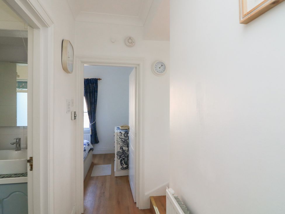 A hallway with a clock and dresser at 4 The Elms Salcombe