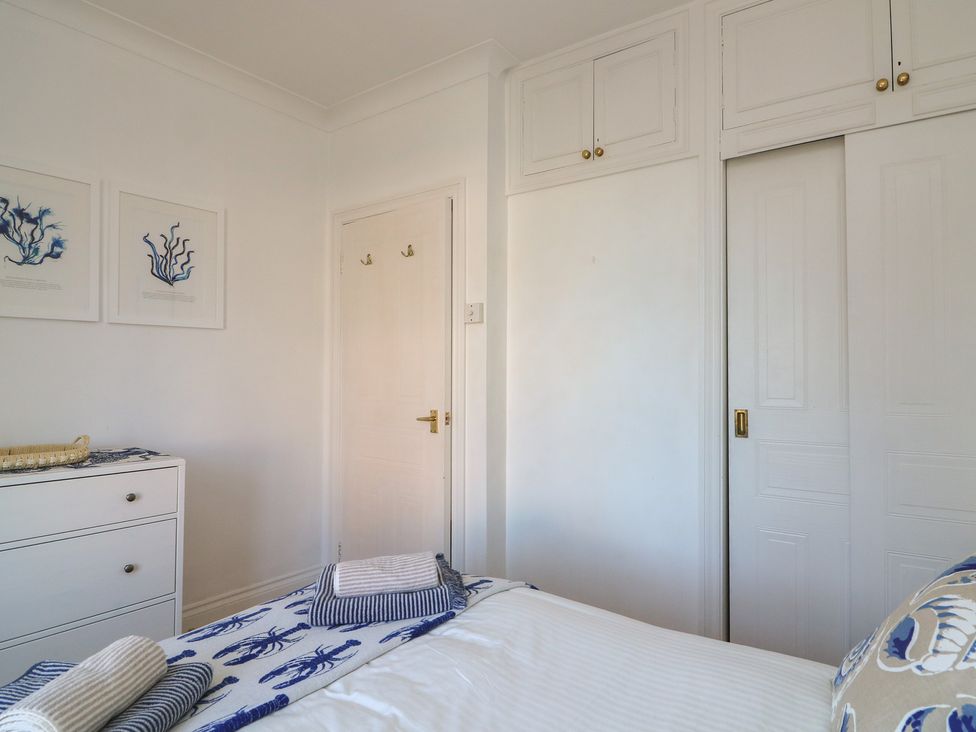 A bedroom with a bed and wardrobe at 4 The Elms in Salcombe