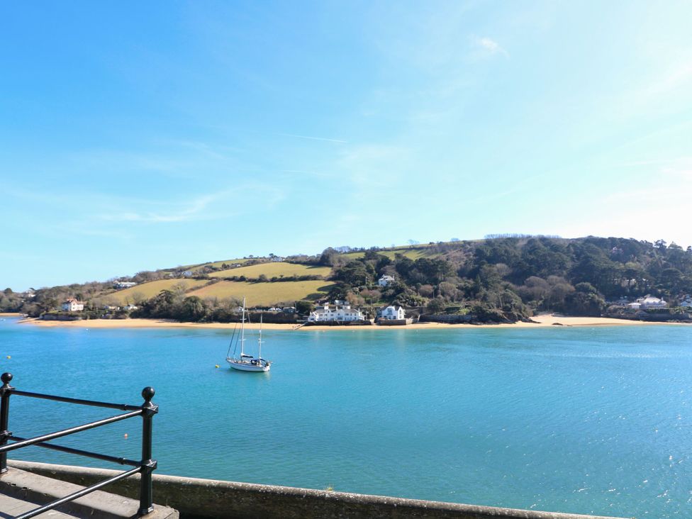 A view of water with a boat and hills in the background at 4 The Elms Salcombe