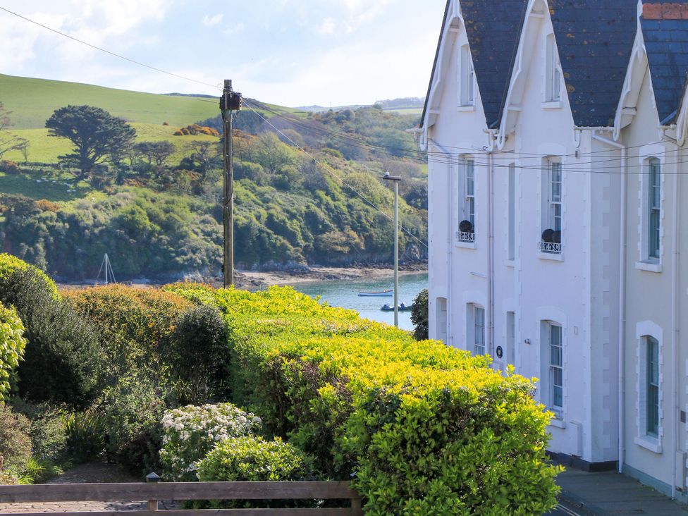 A view of a house with bushes and water at 4 The Elms Salcombe
