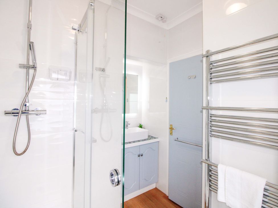 A bathroom with a shower, sink, and towel rail at 4 The Elms Salcombe