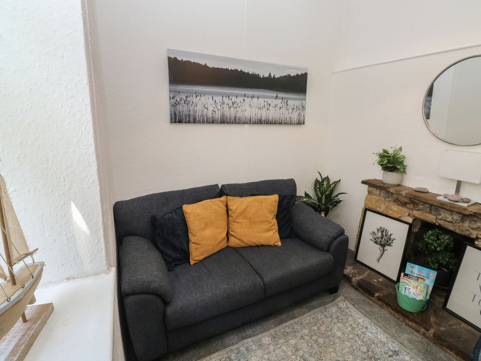 A living room with a sofa and wall art at The Cottage in Budleigh Salterton