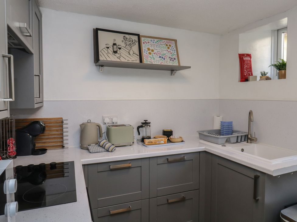 A kitchen with a sink and appliances at The Cottage Budleigh Salterton