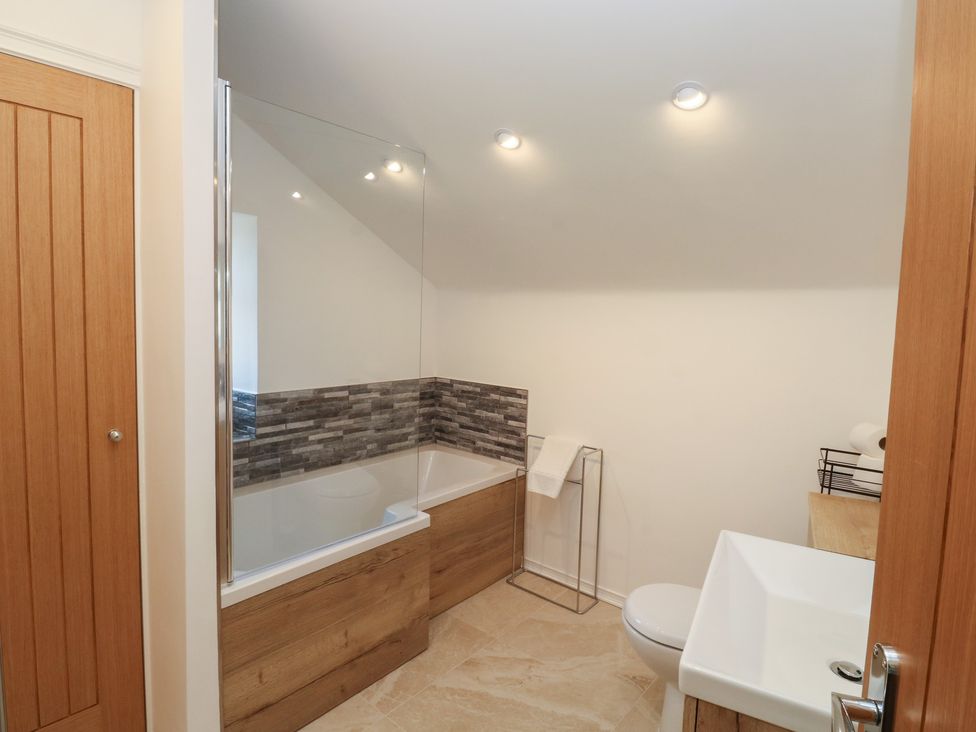 A bathroom featuring a bathtub, toilet, and sink at The Cottage in Budleigh Salterton