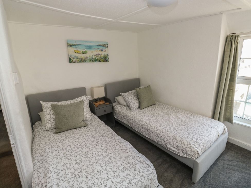 A bedroom with two single beds and a nightstand at The Cottage in Budleigh Salterton