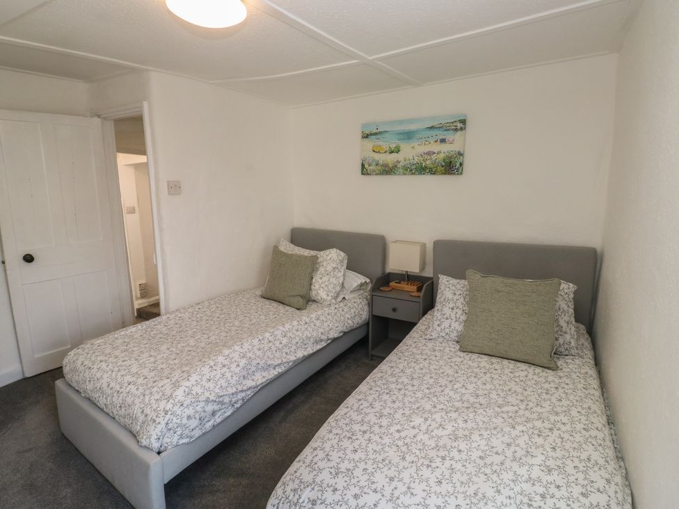 A bedroom with two single beds and bedside table at The Cottage in Budleigh Salterton