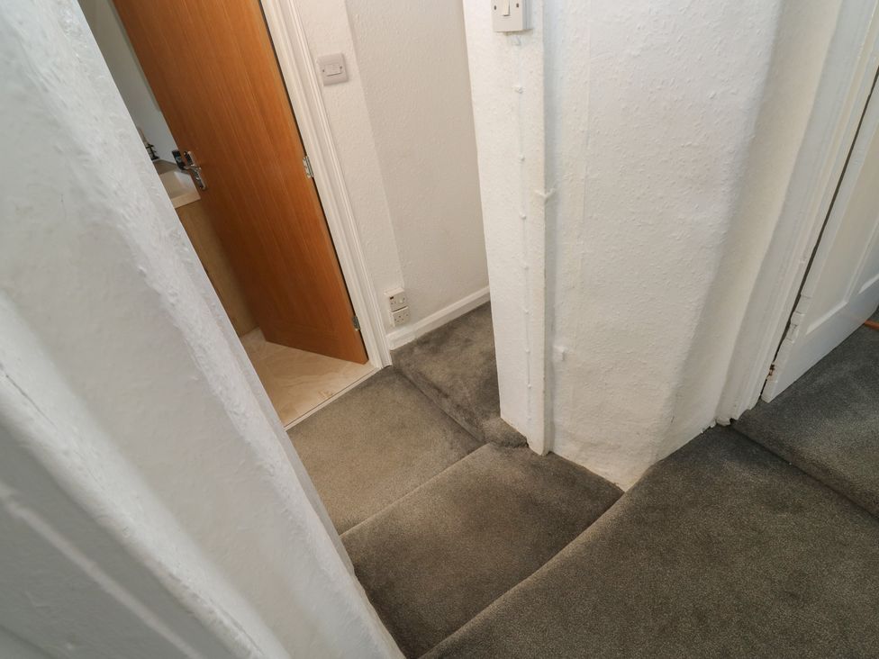 A hallway with carpet and doors leading to other rooms at The Cottage in Budleigh Salterton