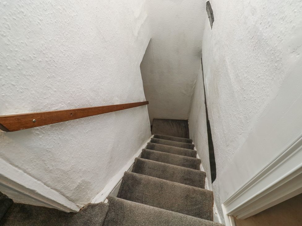 A staircase with a handrail and carpet at The Cottage Budleigh Salterton