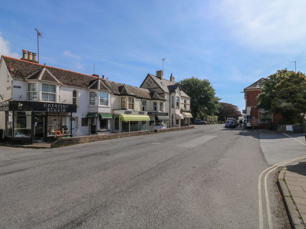 A street view with shops and vehicles at The Cottage in Budleigh Salterton