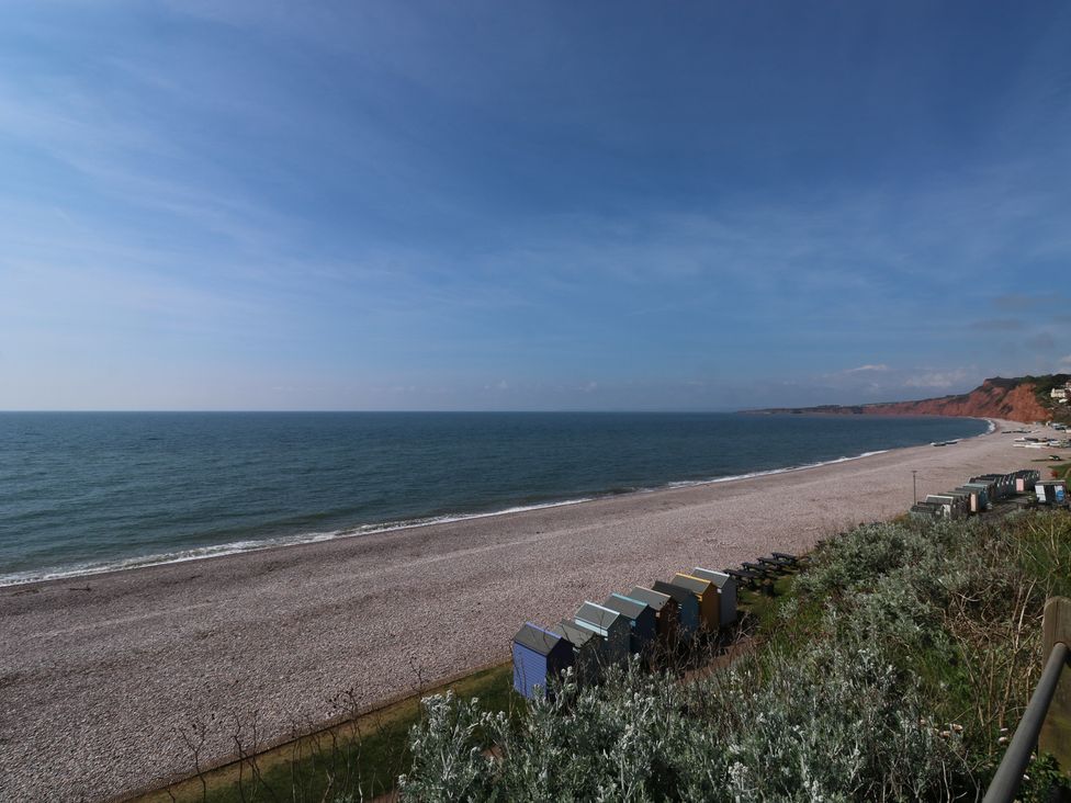 A beach with pebbles and beach huts at The Cottage in Budleigh Salterton