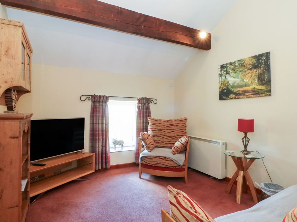 A living room with a television and chair at Pearls Farm One Wildboarclough near Macclesfield