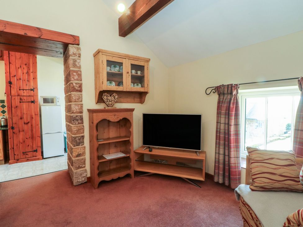 A living room with a television and a shelf at Pearls Farm One Wildboarclough near Macclesfield