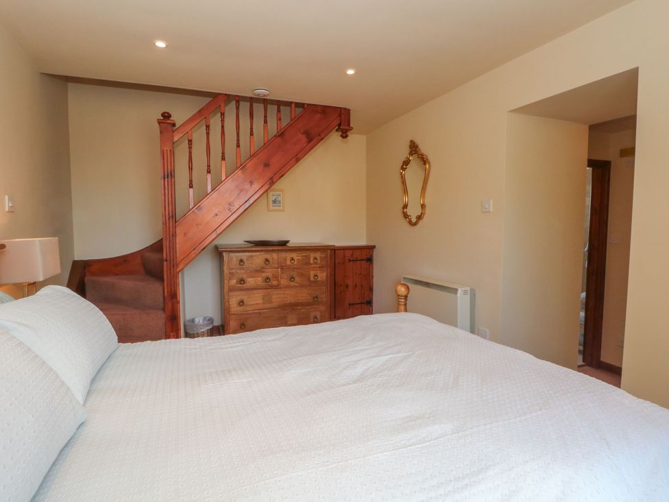 A bedroom with a bed and a staircase at Pearls Farm One, Wildboarclough near Macclesfield