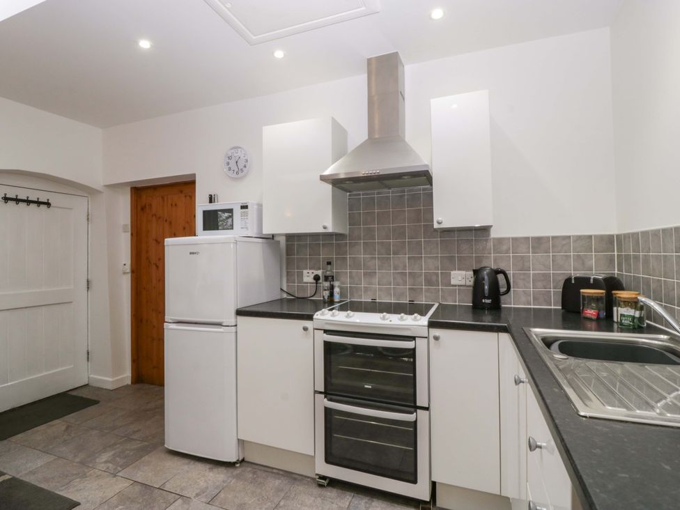 A kitchen with appliances and cabinets at Castle Rag in Lydney