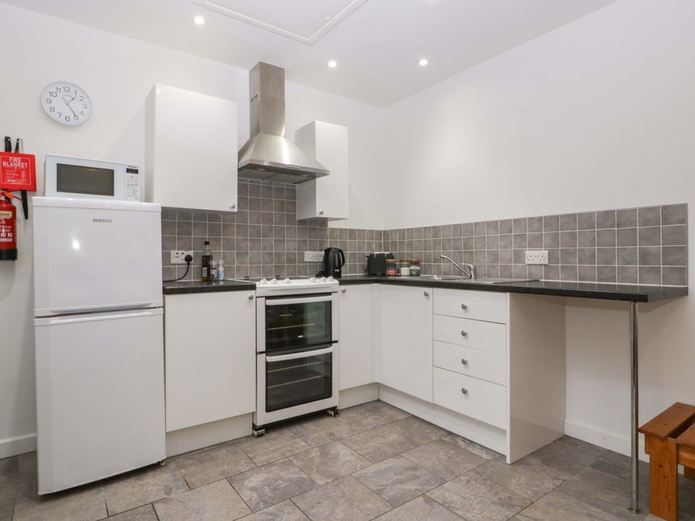 A kitchen with appliances and cabinets at Castle Rag in Lydney