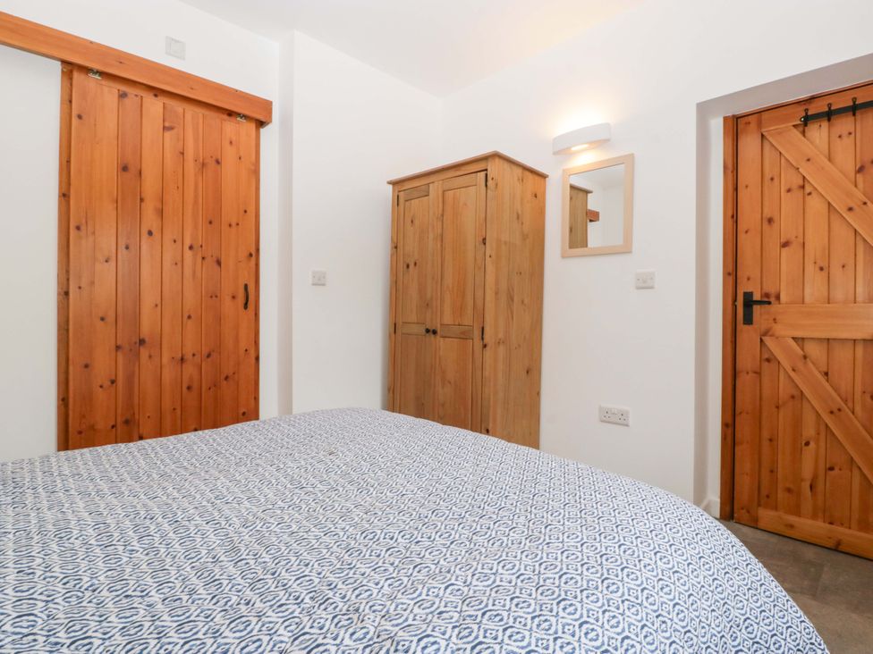 A bedroom with a bed and wooden furniture at Castle Rag in Lydney