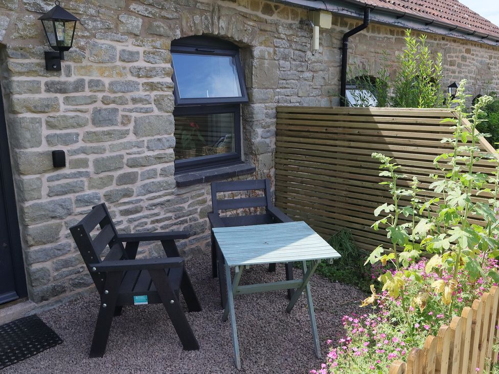 An outdoor seating area with chairs and a table at Castle Rag in Parkend