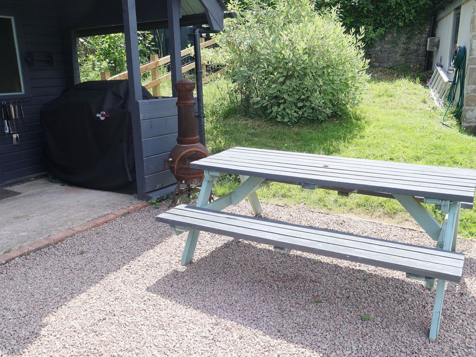 An outdoor space with a picnic table and a barbecue grill at Castle Rag in Parkend