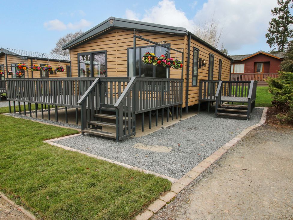 A cabin with a deck and planter boxes at Tulip in Eardisland
