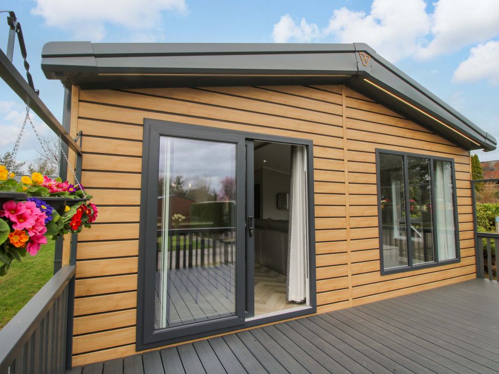 An exterior view of a house with a deck and large windows at Tulip in Eardisland