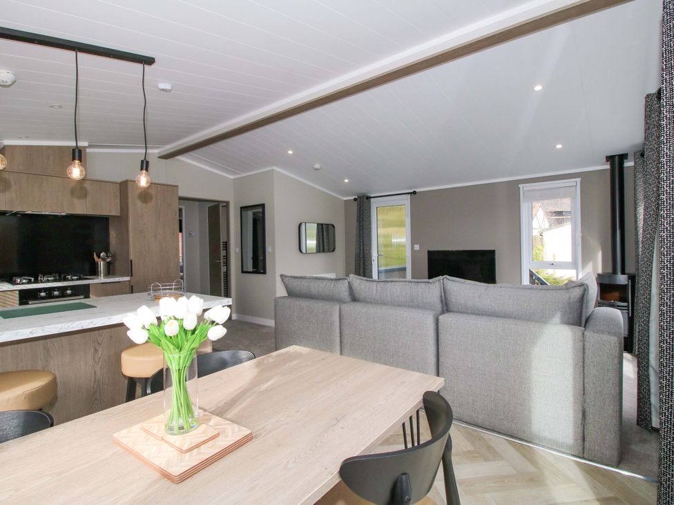 A living room with a sofa and dining area at Tulip in Eardisland