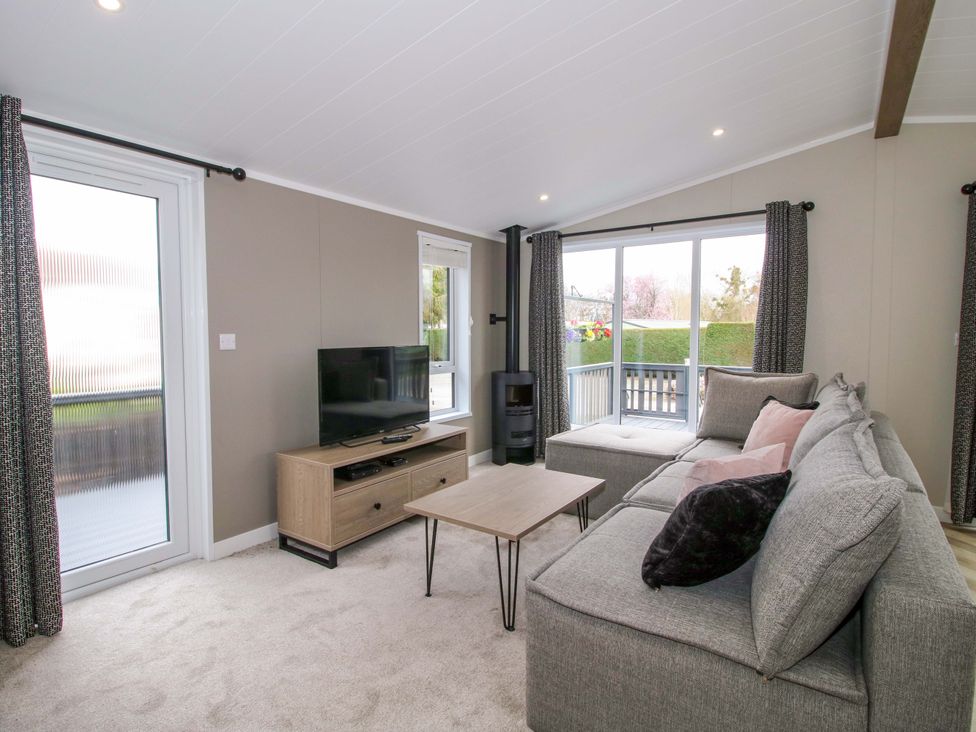 A living room with a sofa and television at Tulip in Eardisland