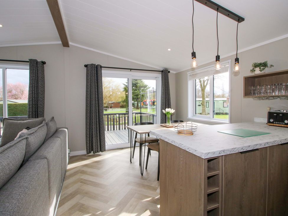 A living room with a sofa and dining area at Tulip in Eardisland