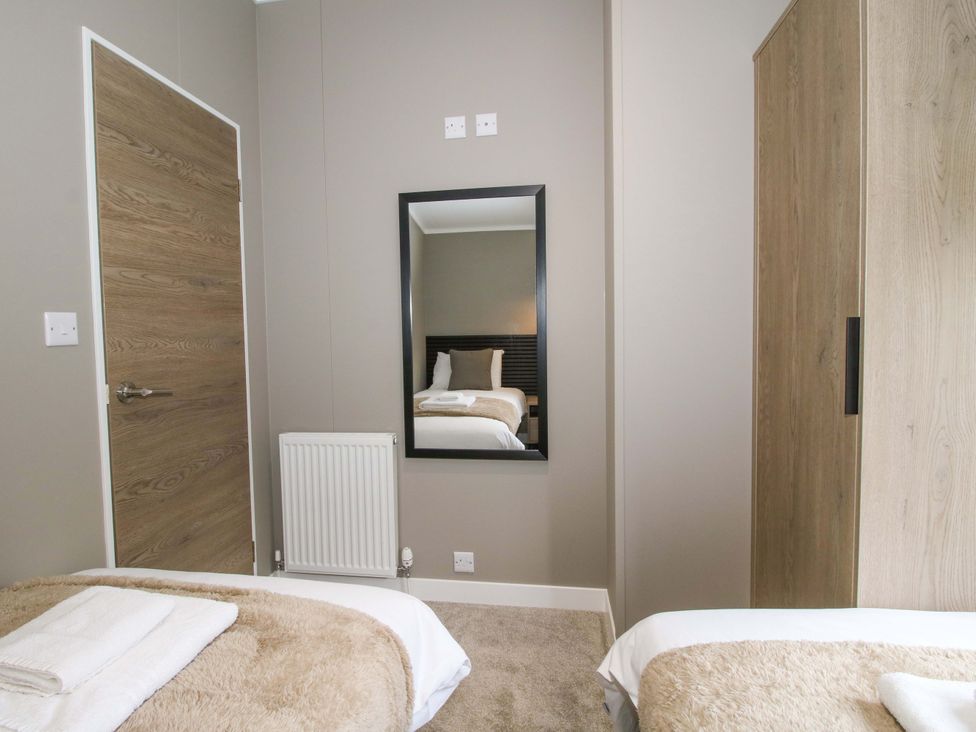 A bedroom with a bed and mirror at Tulip in Eardisland