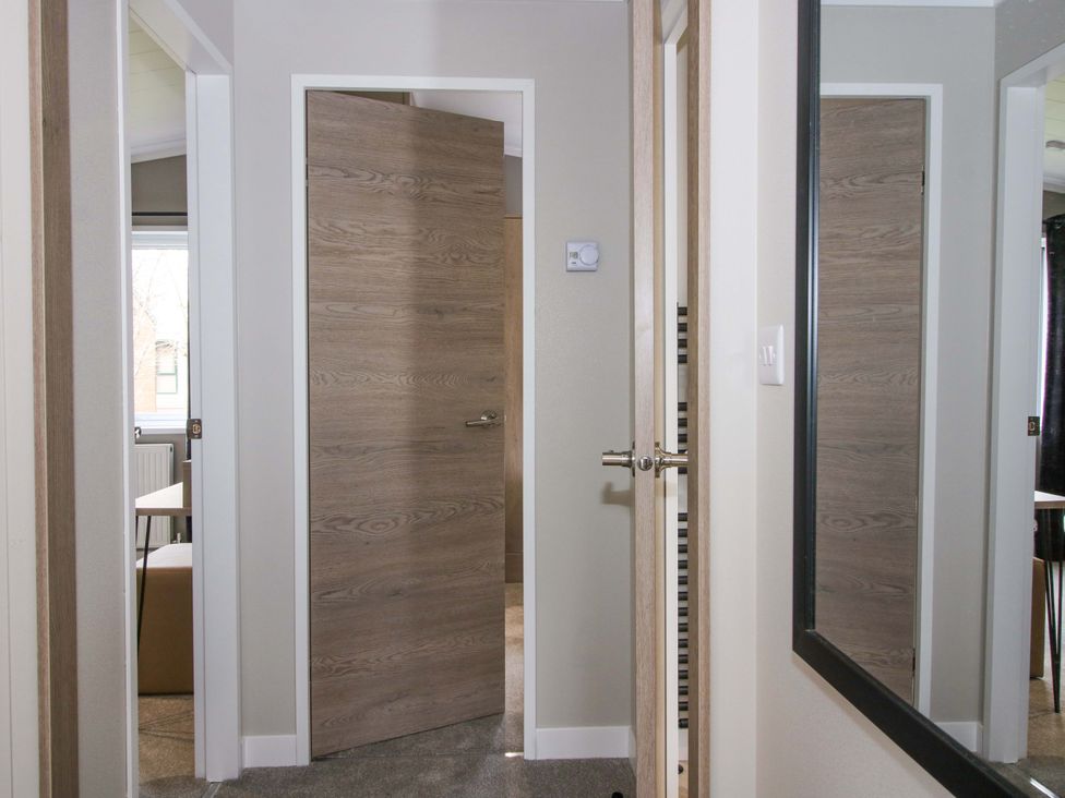 A corridor with a door and mirror at Tulip in Eardisland