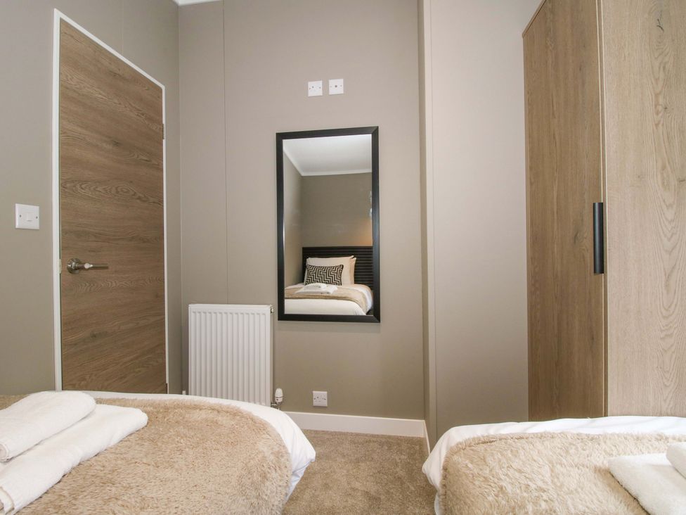 A bedroom with a bed and wardrobe at Poppy in Eardisland