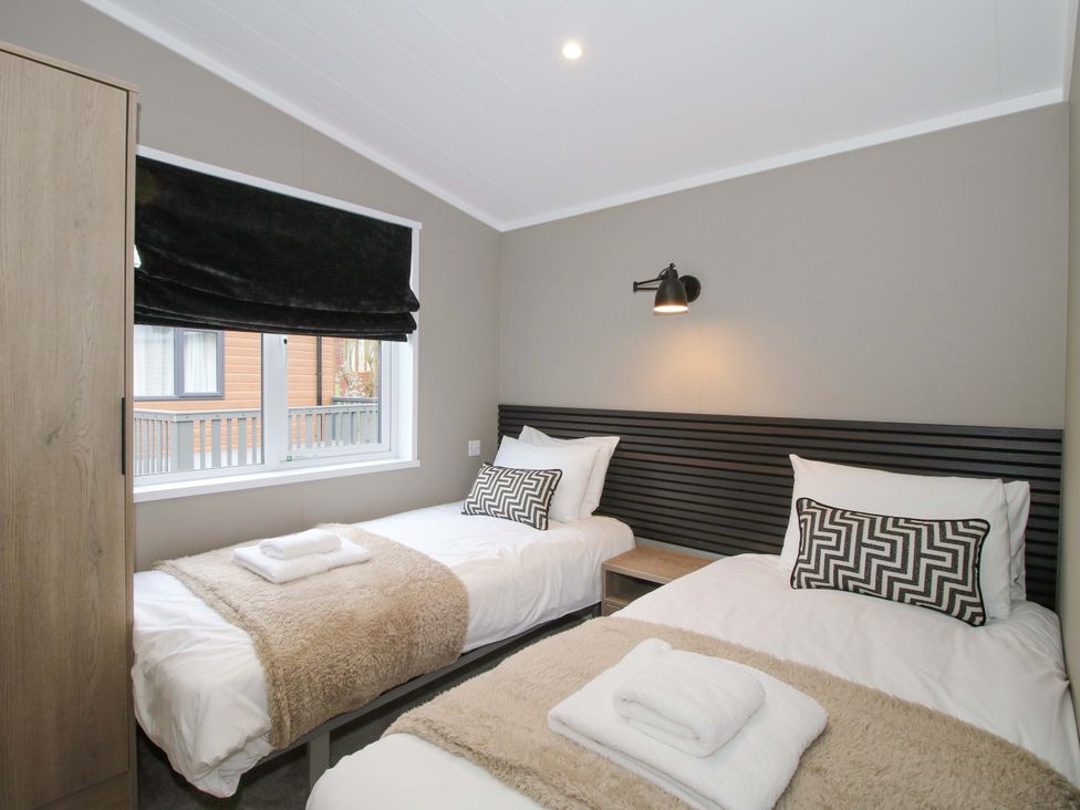 A bedroom with two beds and a window at Poppy in Eardisland