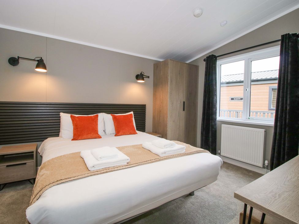 A bedroom with a bed and window at Poppy in Eardisland