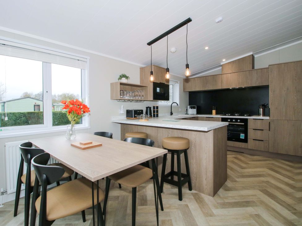 A kitchen with dining table and stools at Poppy in Eardisland