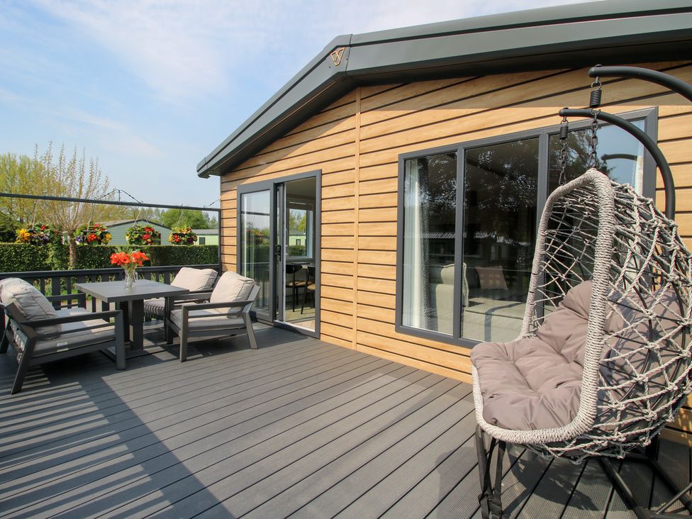 An outdoor patio with a table and chairs at Poppy Eardisland