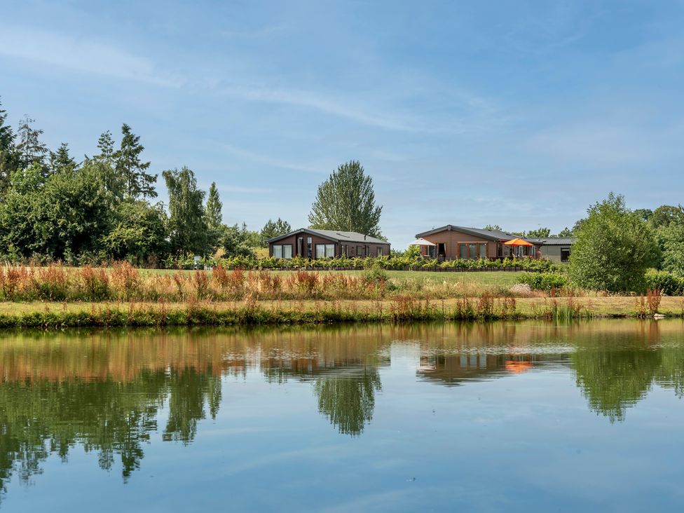 A view of houses by a pond at Poppy in Eardisland