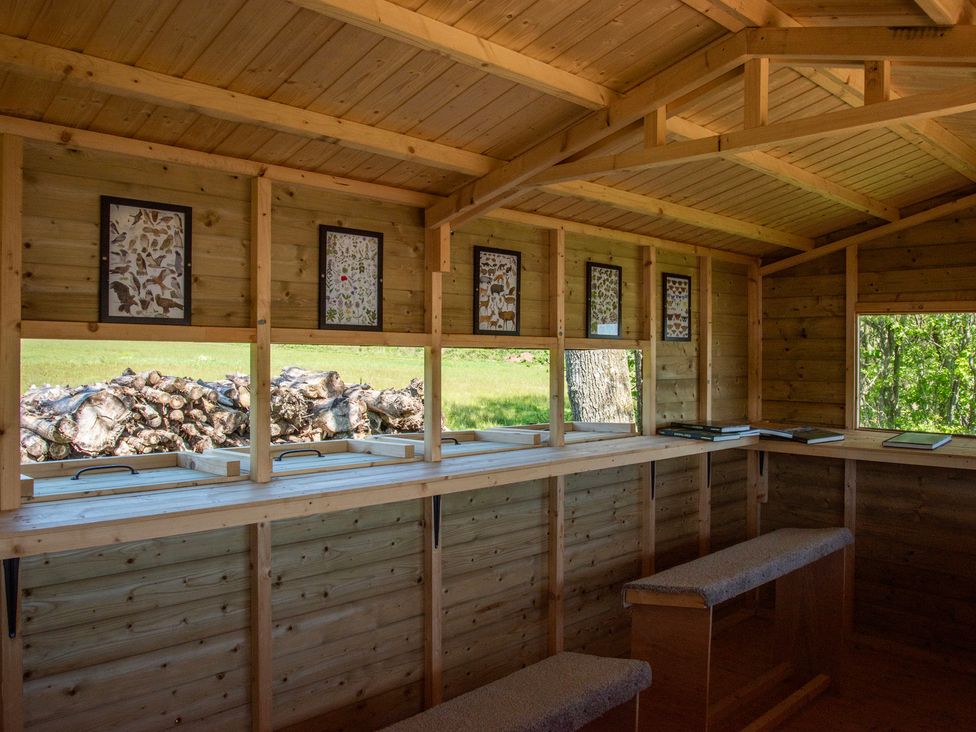 An indoor space with wooden walls and benches at Poppy in Eardisland