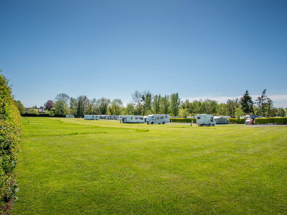 A caravan site with several caravans on grass at Poppy in Eardisland