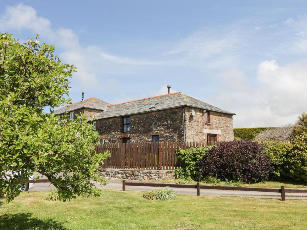 A stone building with a wooden fence at Applestore in Wadebridge