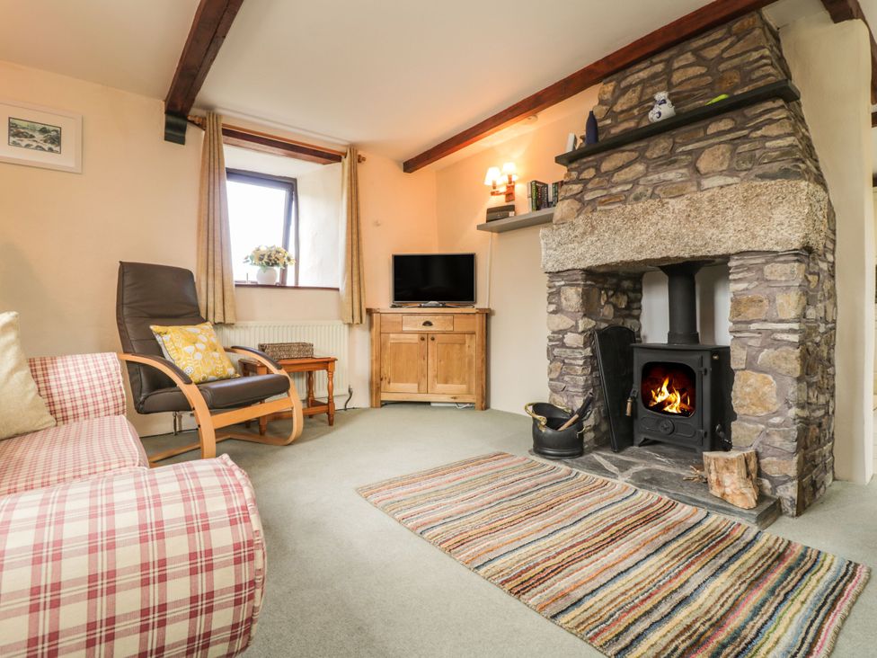 A living room with a fireplace and sofa at Applestore in Wadebridge