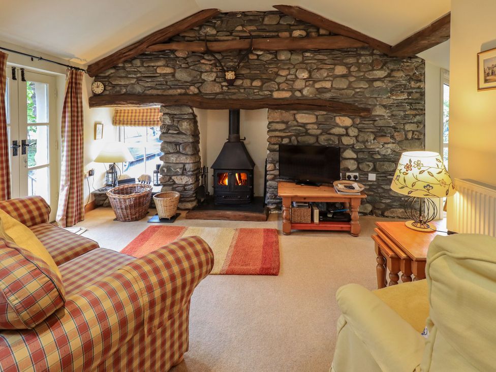 A living room with a fireplace and sofa at Beckside Studio in Penrith