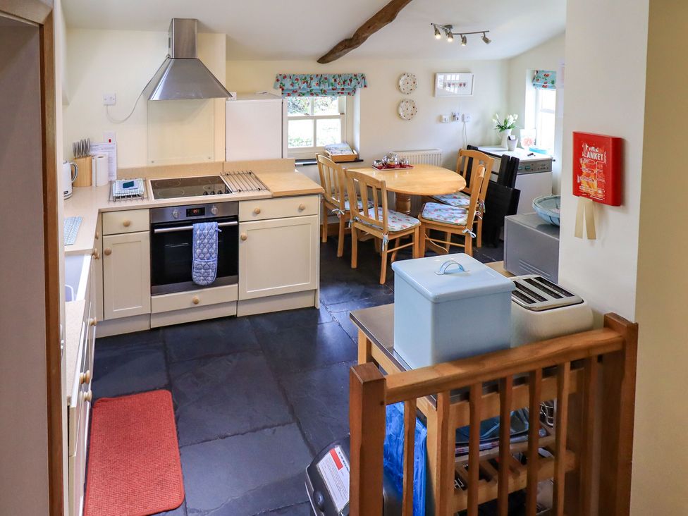 A kitchen with an oven and dining table at Beckside Studio in Penrith