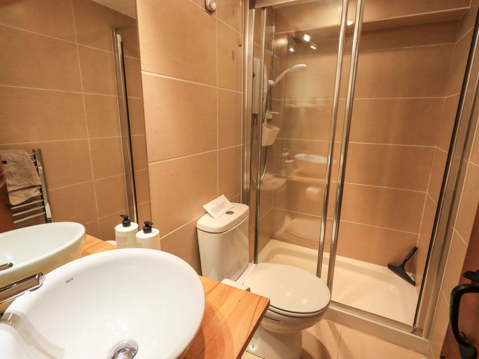 A bathroom with a shower, sink, and toilet at Beckside Studio in Penrith