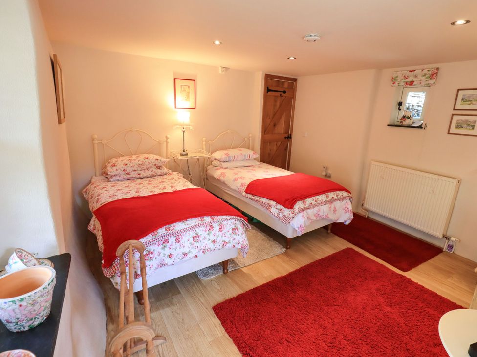 A bedroom with two beds and a lamp at Beckside Studio in Penrith