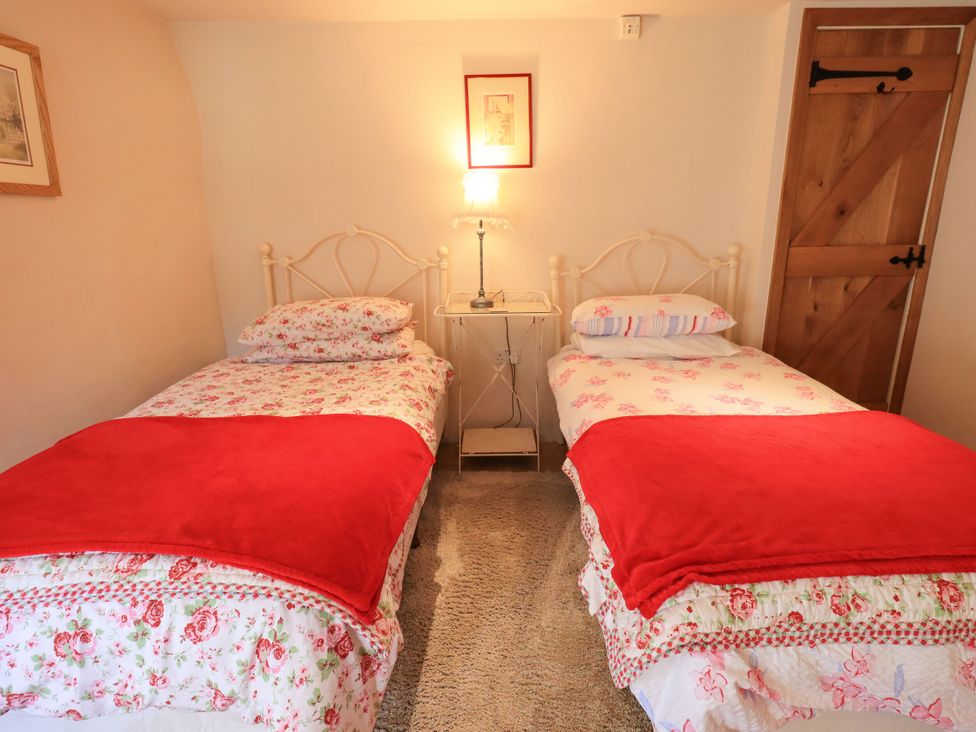 A bedroom with two beds and a bedside table at Beckside Studio in Penrith