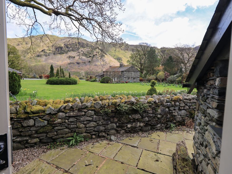 A garden with a stone wall and mountains in the background at Beckside Studio in Penrith