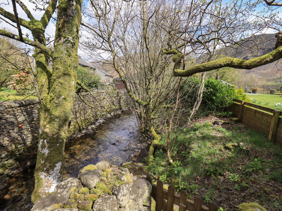 A stream next to a stone wall and trees at Beckside Studio Penrith